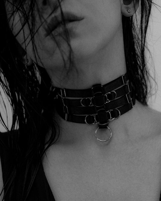 Black four strap woven posture choker/choker featuring a woven gold o-ring design in the centre 